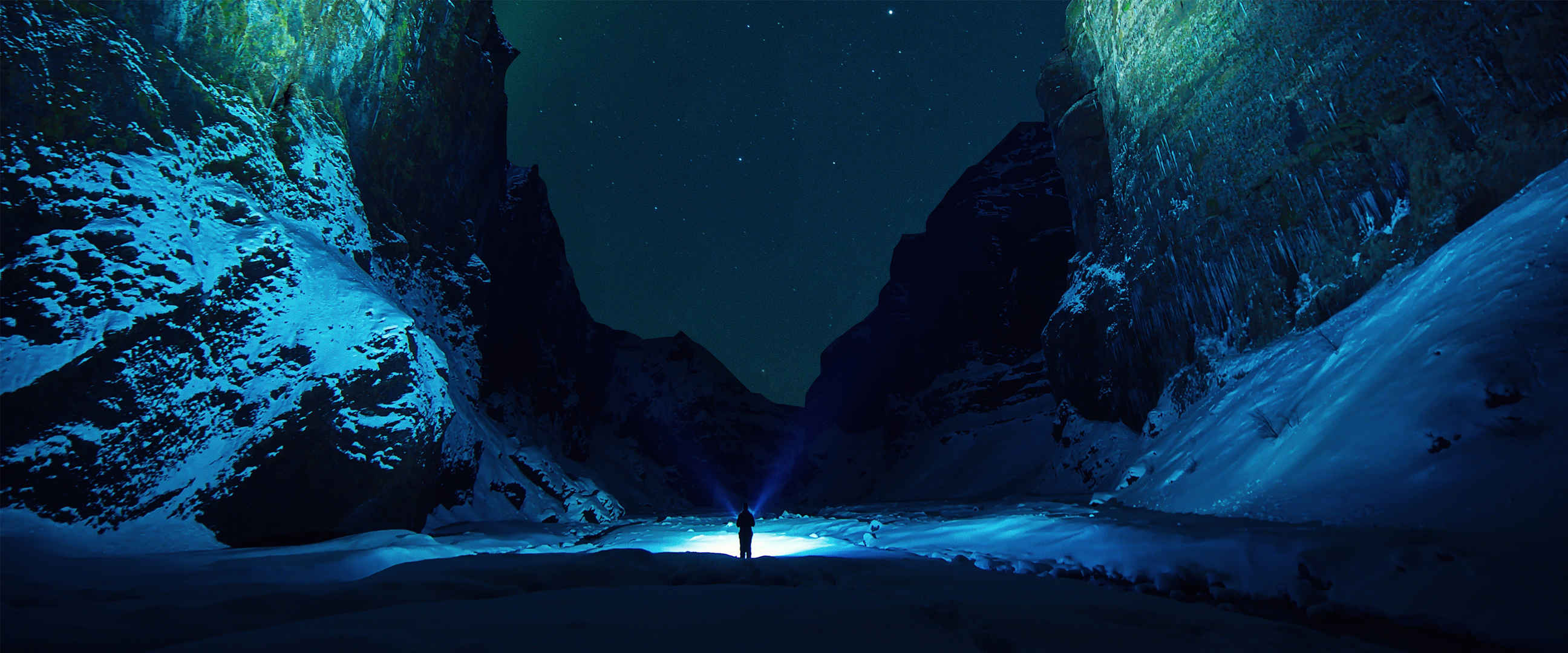 深夜雪山里一个人拿着手电筒照亮前途孤独图片-
