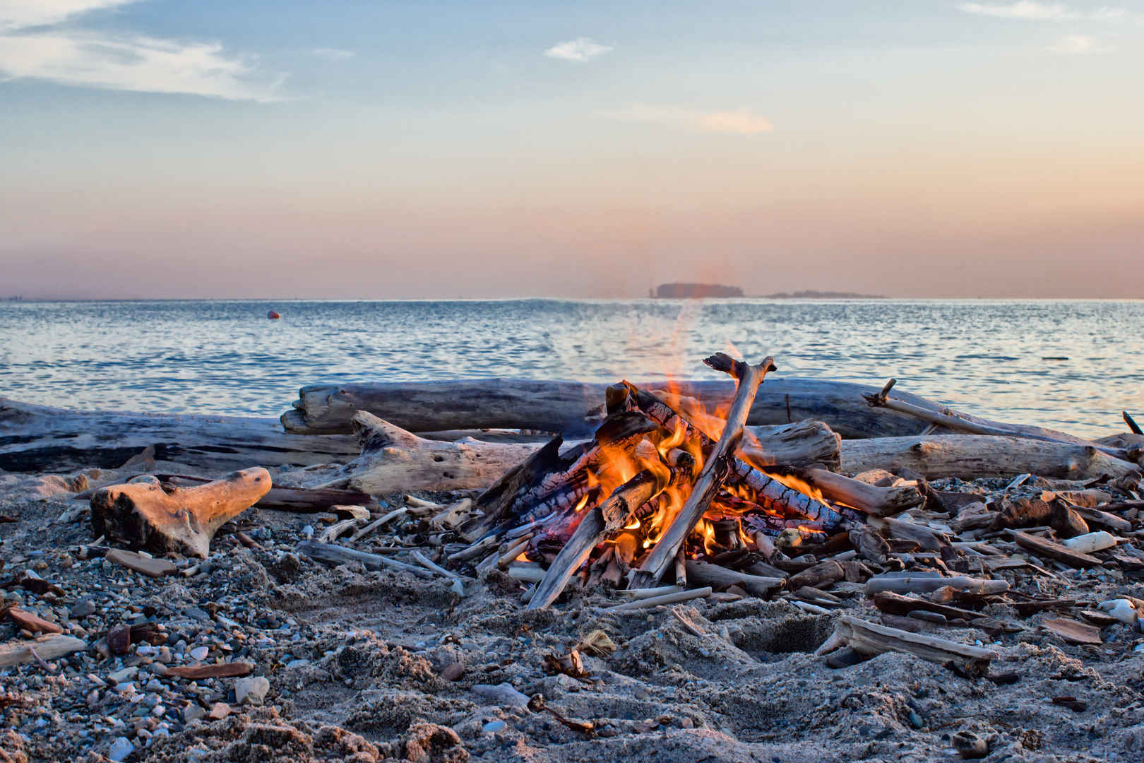 清晨大海边上的篝火取暖图片-