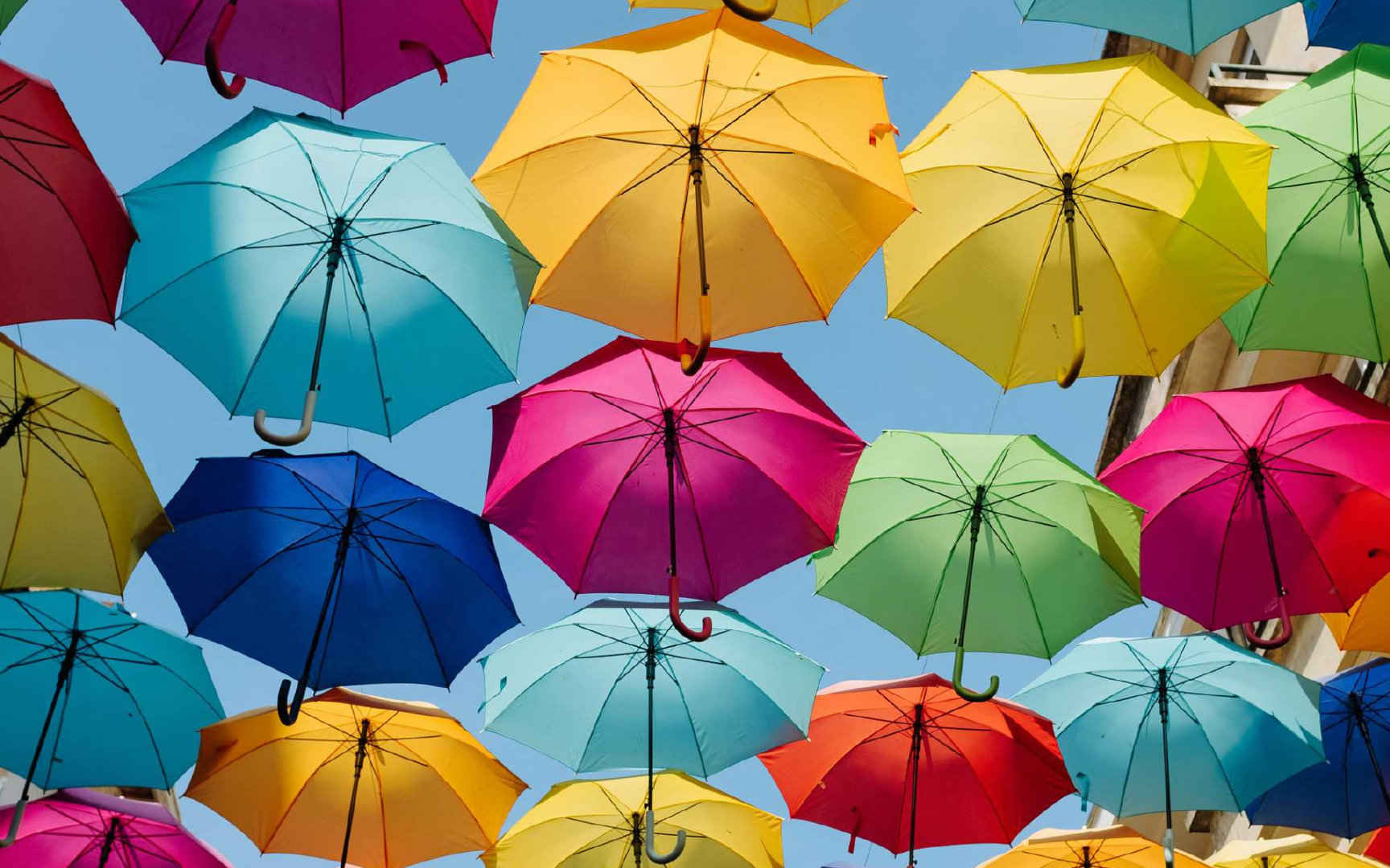 挂在街道上空的七彩雨伞的创意街景电脑壁纸 ​​​​