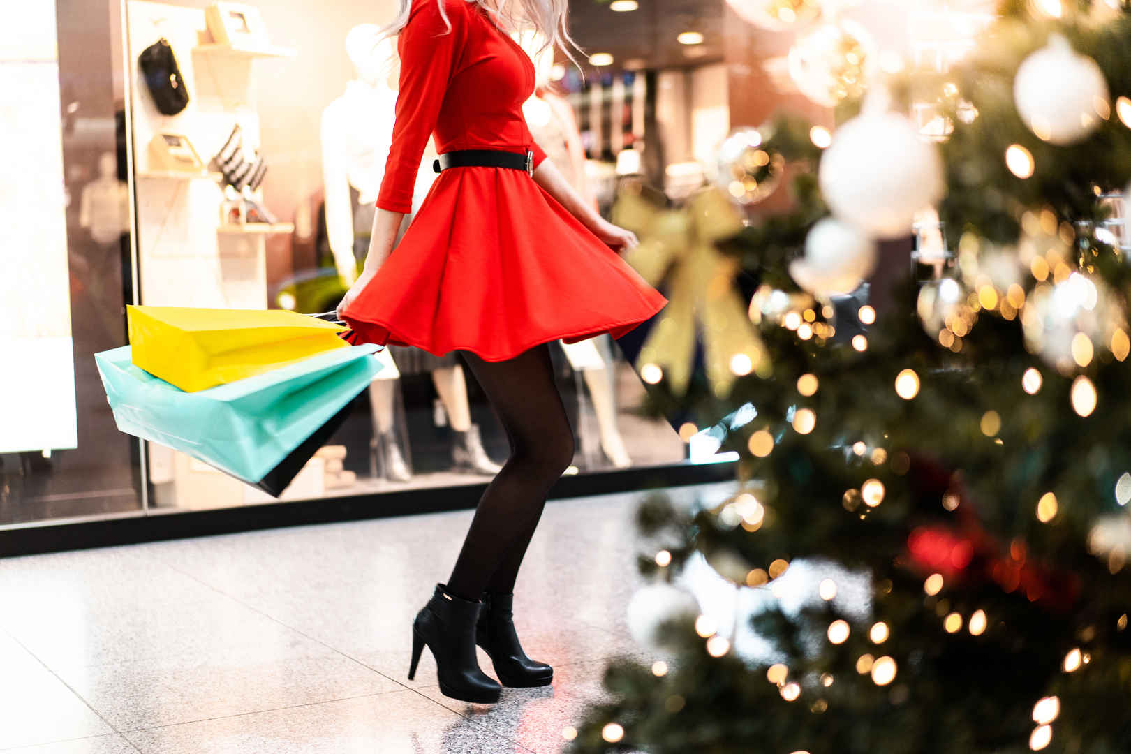穿红裙子黑色丝袜的女人享受圣诞购物4k高清图片-