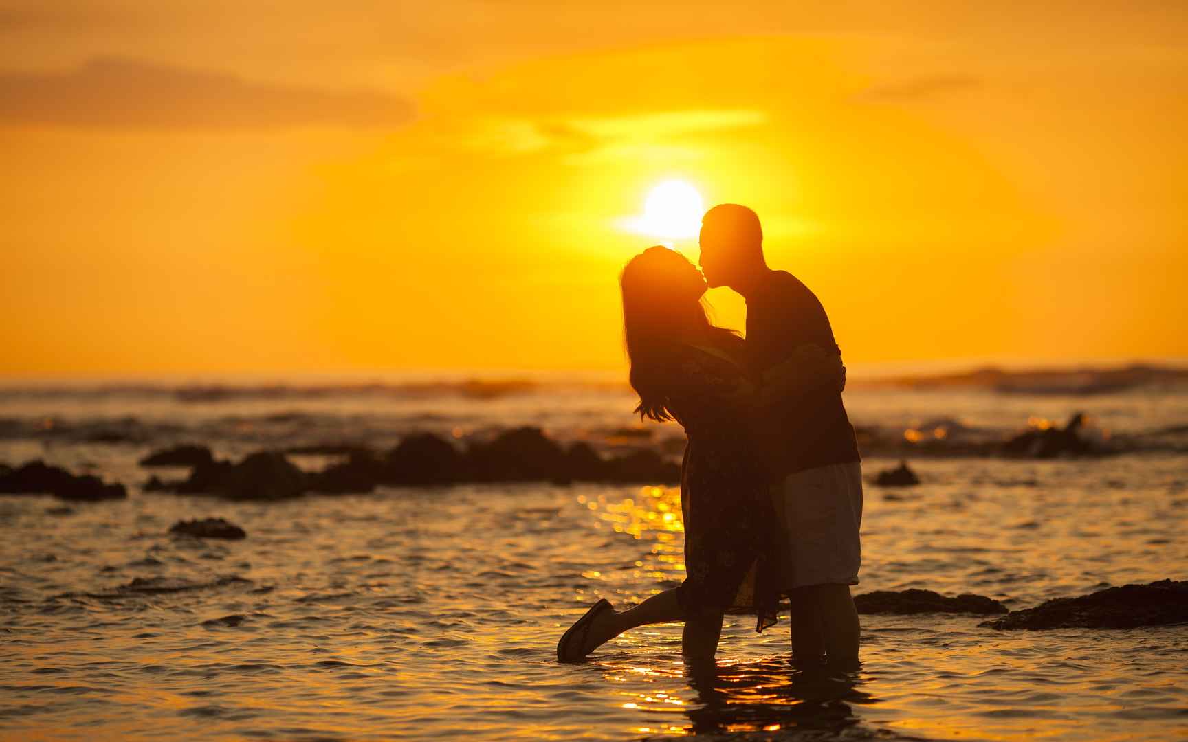 海边夕阳下拥吻的情侣浪漫高清壁纸-