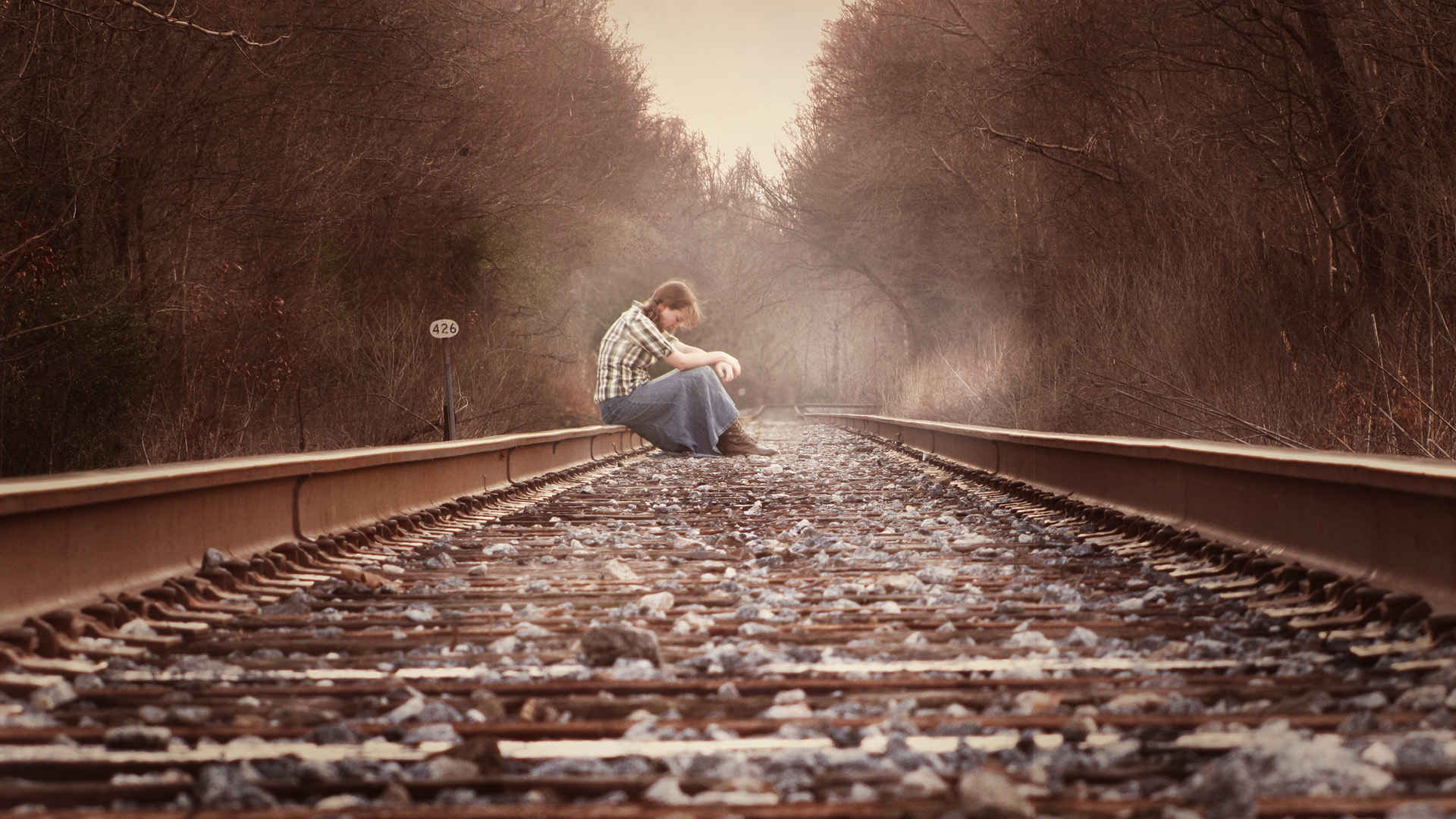 一个人坐在铁轨上沮丧图片-