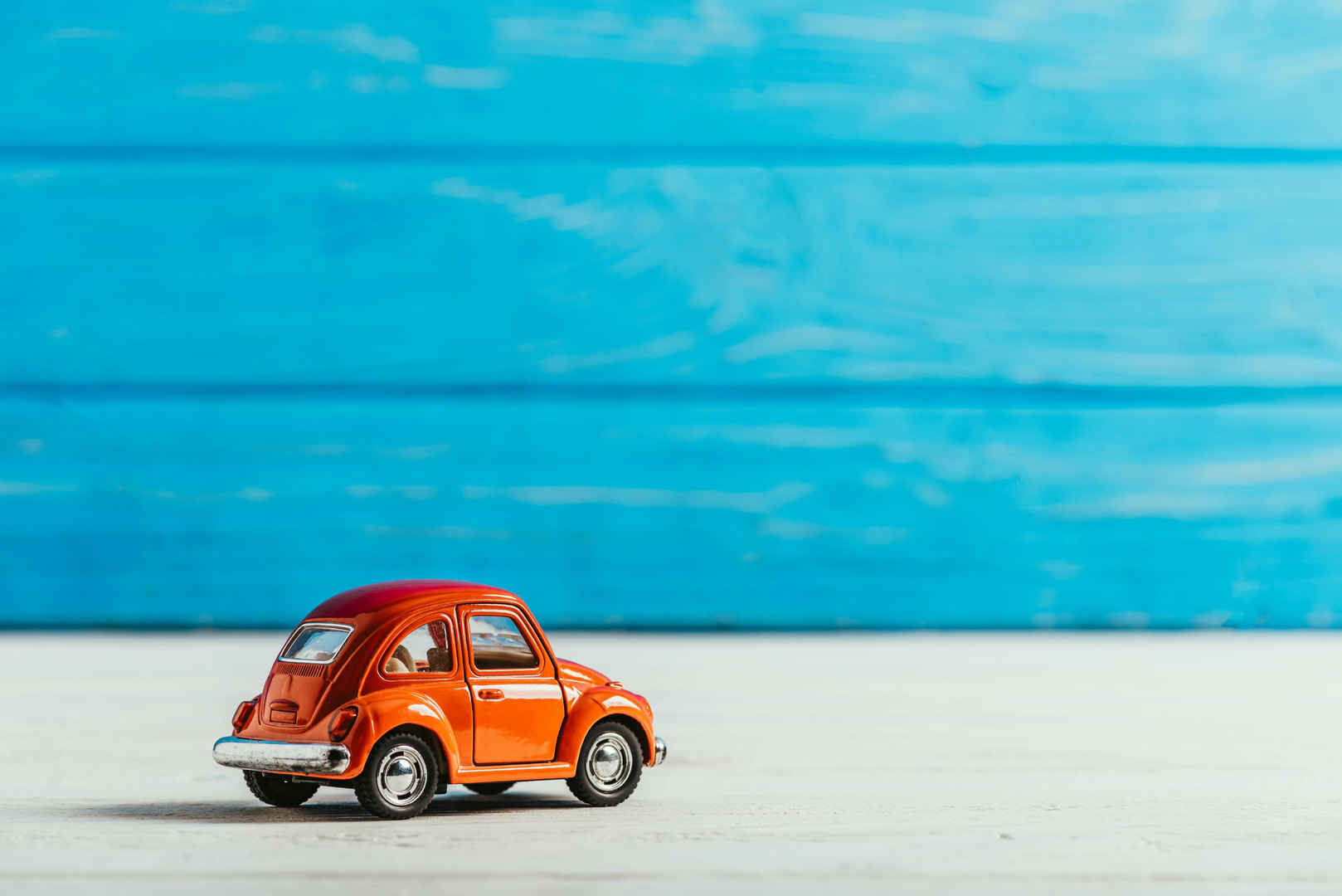 蓝色木制背景的红色玩具车图片