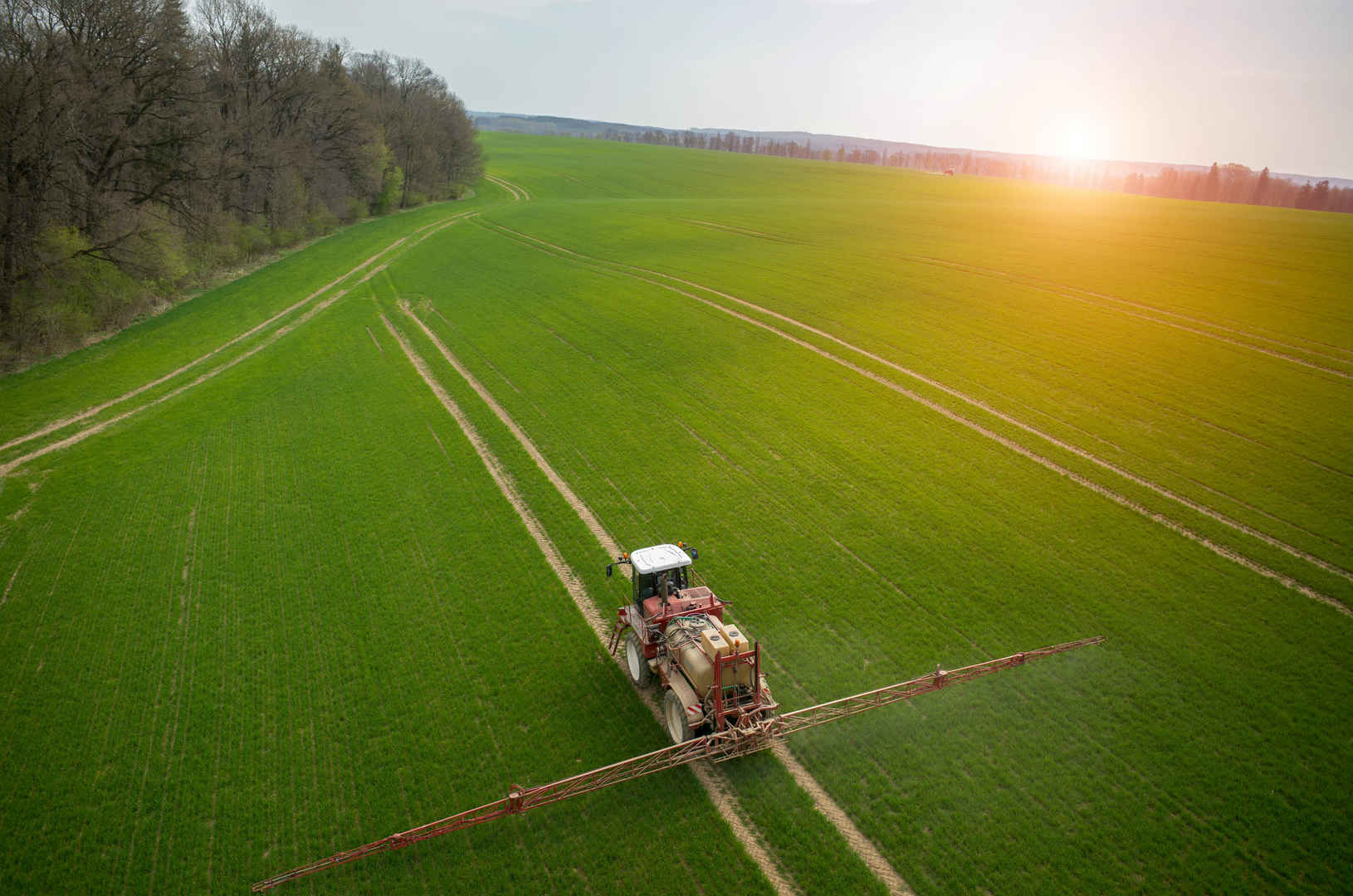 绿色大地上拖拉机喷涂农药图片-