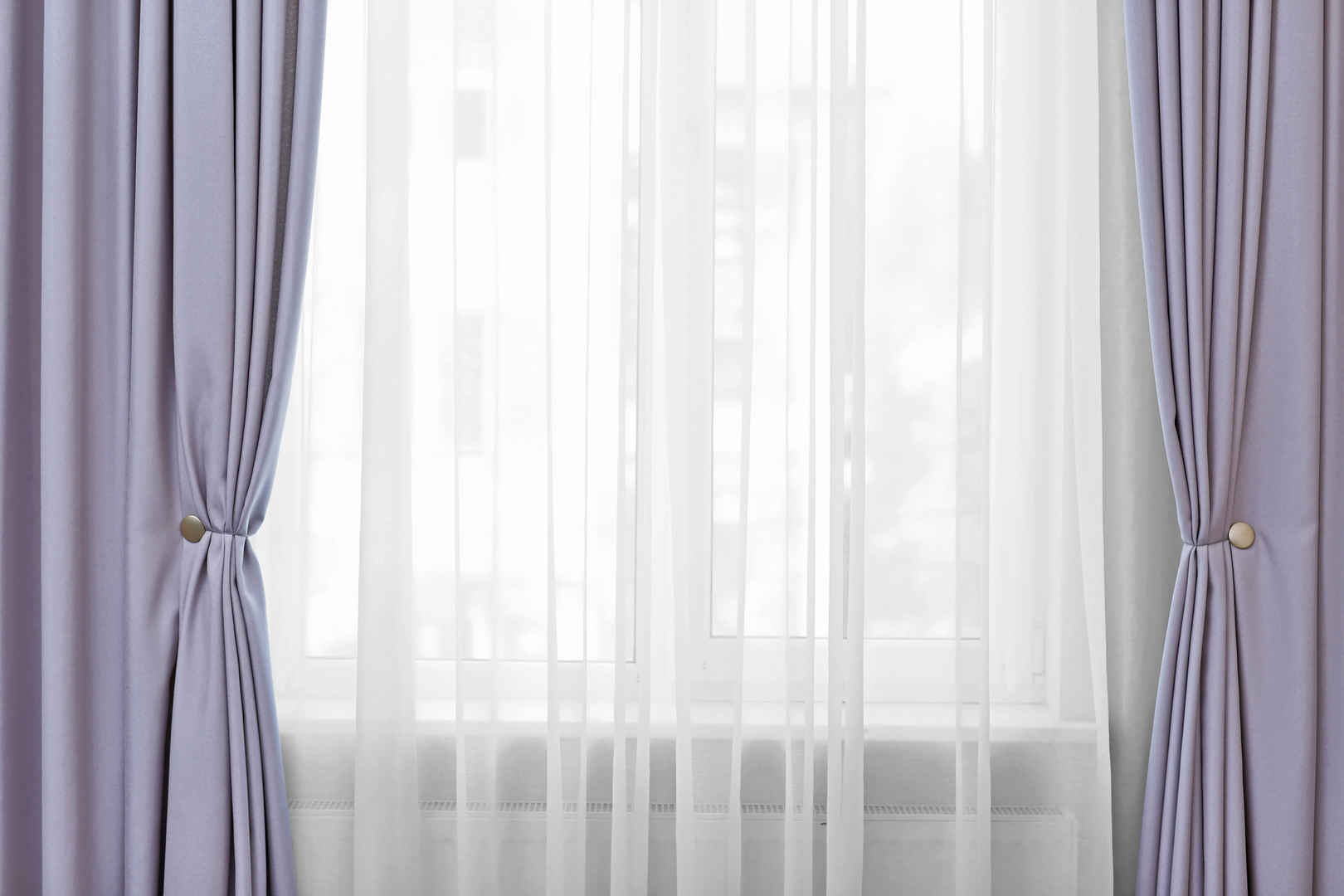 房间窗口挂着白色和灰色的窗帘