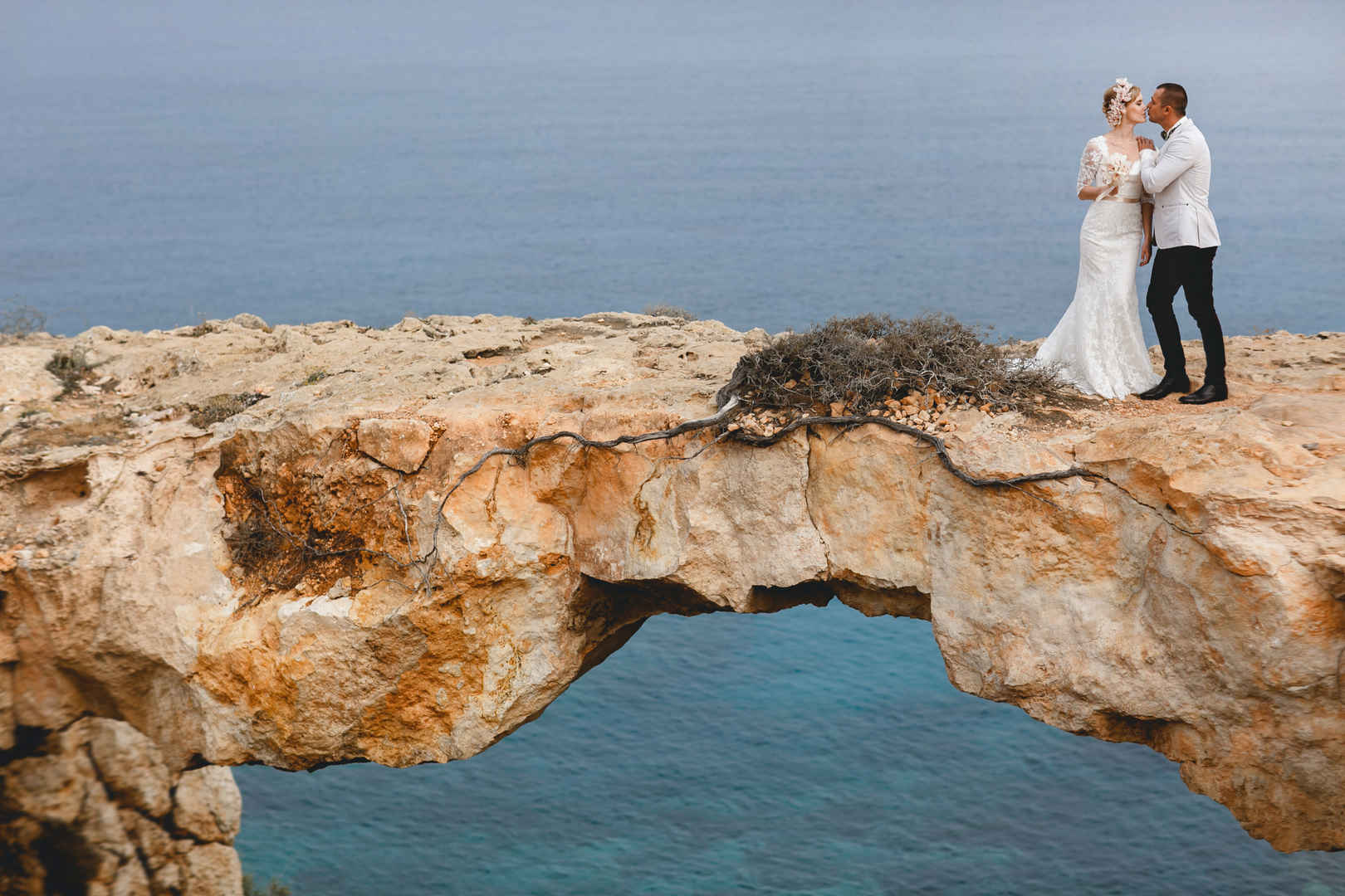 新郎新娘在海上岩石桥亲吻