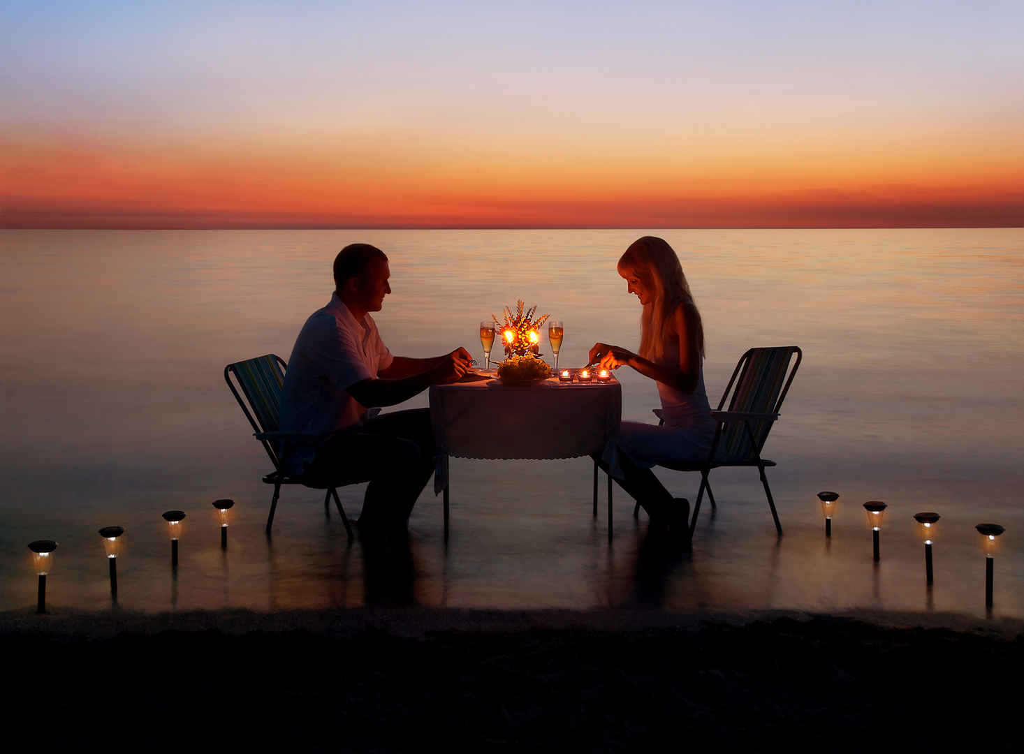 恩爱夫妻日落海滩上浪漫晚餐